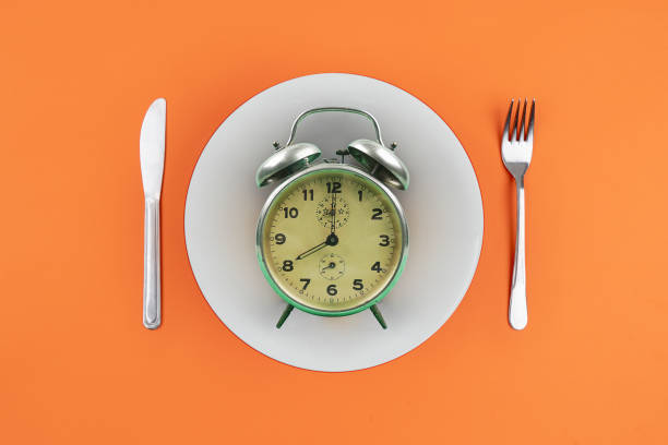 temps de manger avec la fourchette de plaque d'horloge - jeûne photos et images de collection